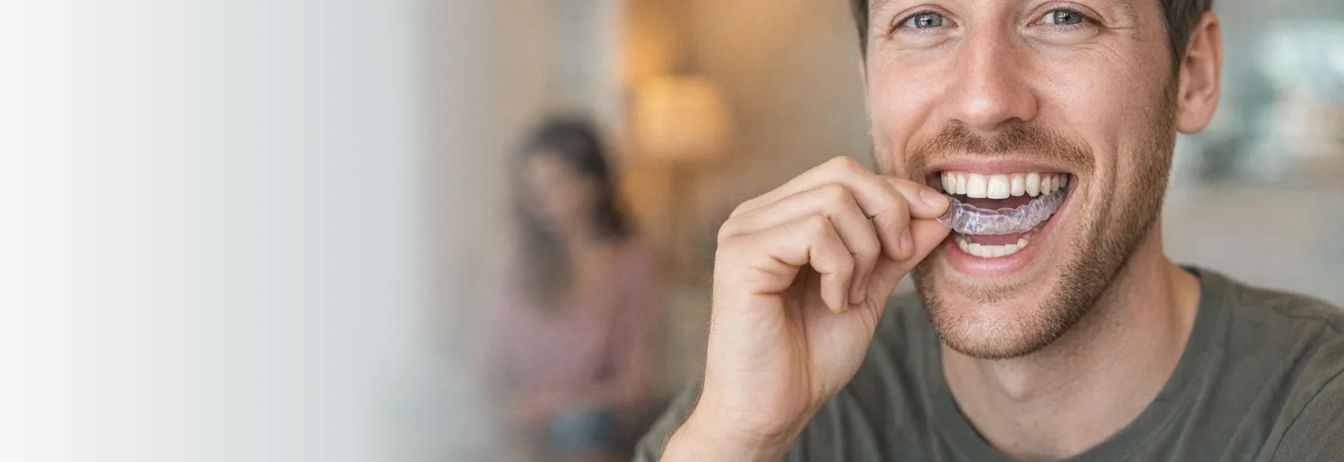 Smiling man fitting a clear mouth guard