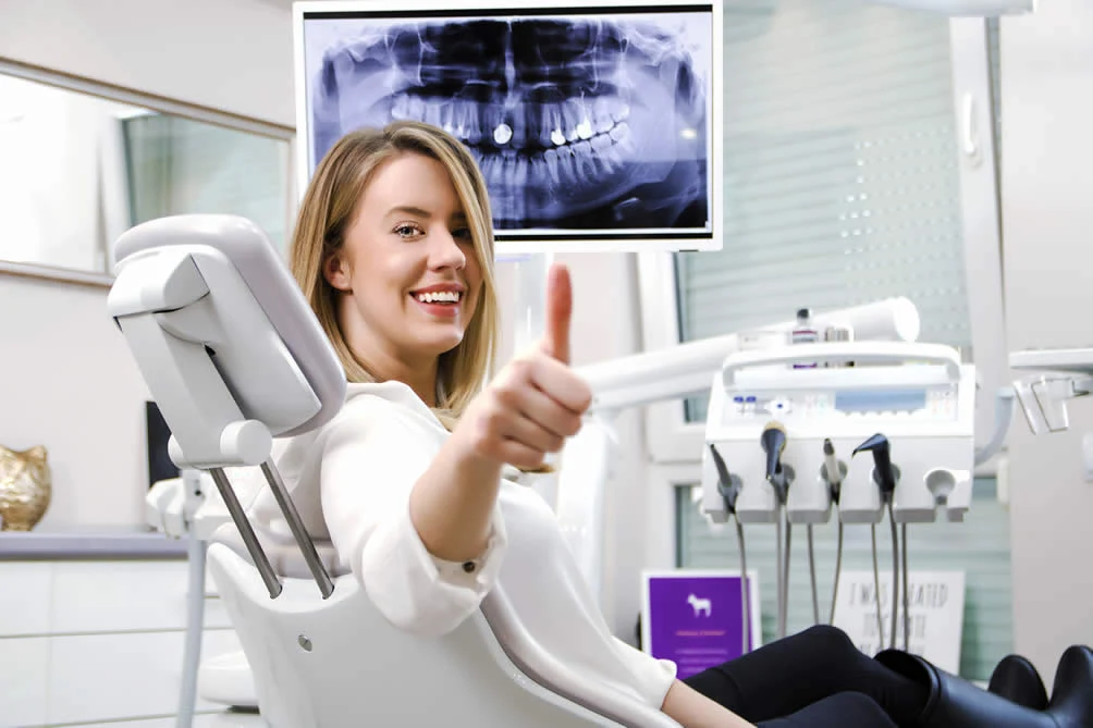 Patient in the chair at Village Dental with an X-ray on screen